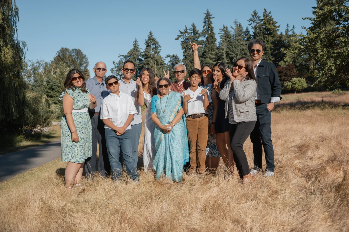 Documentary family reunion photography — extended family laughing together in a sunlit field