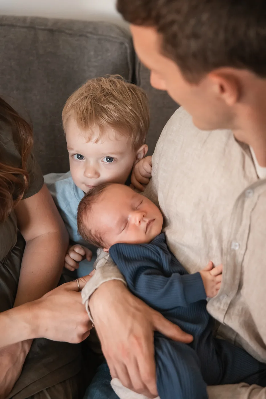 Documentary newborn session — toddler leaning in close to a sleeping newborn sibling