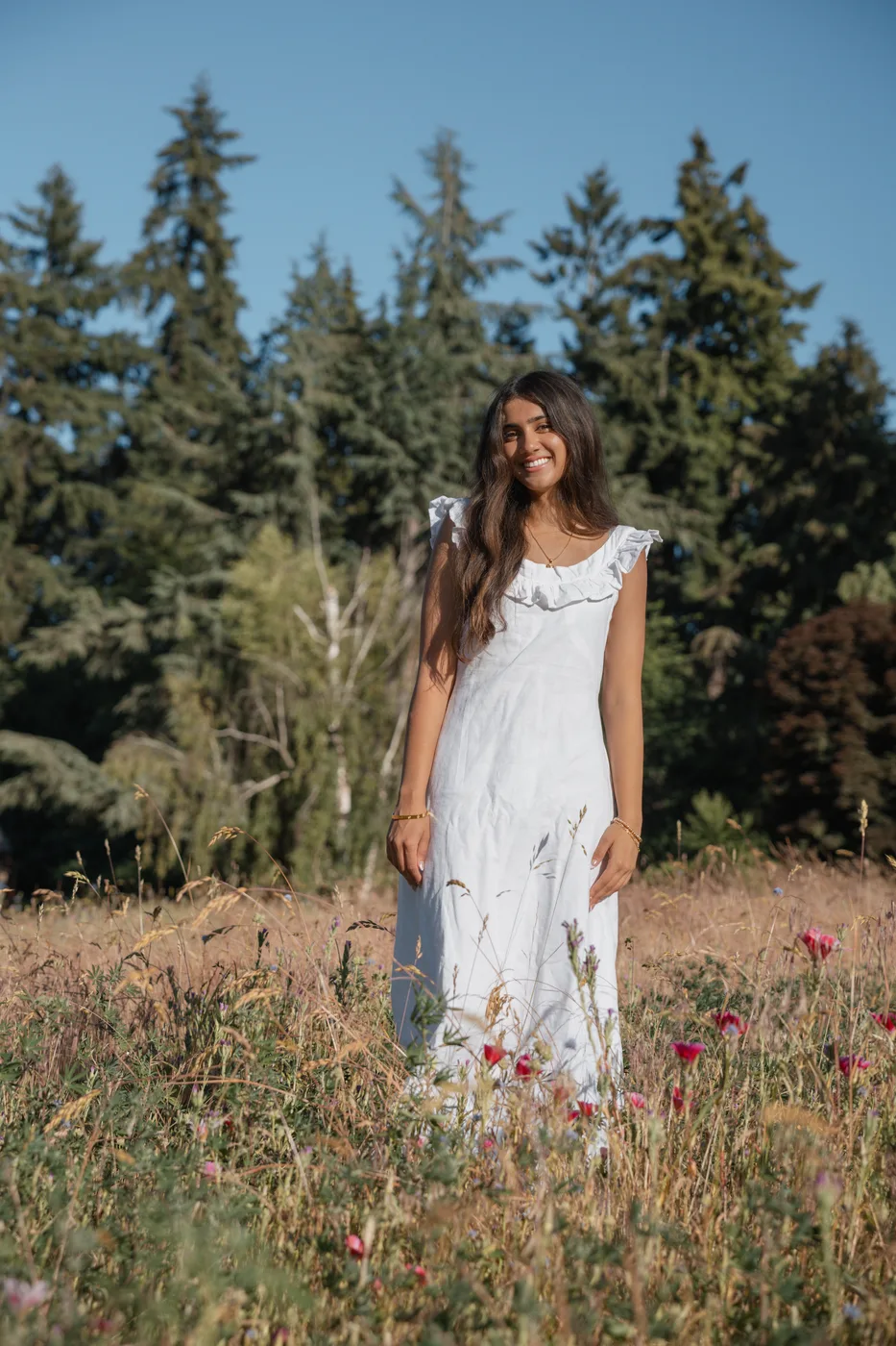 Documentary portrait of a young woman smiling in a wildflower field
